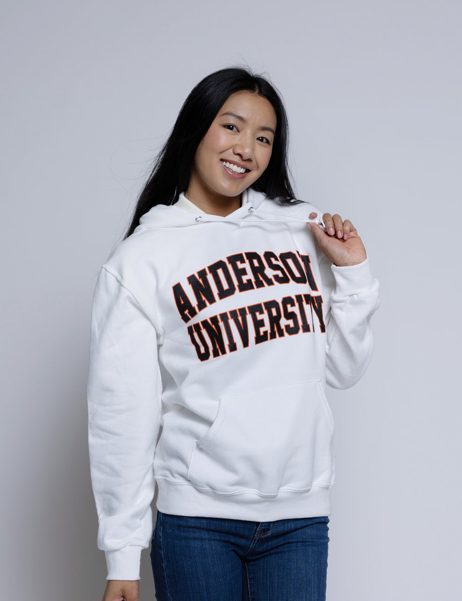 Person wearing a white hoodie with 'Anderson University' printed on it against a plain background