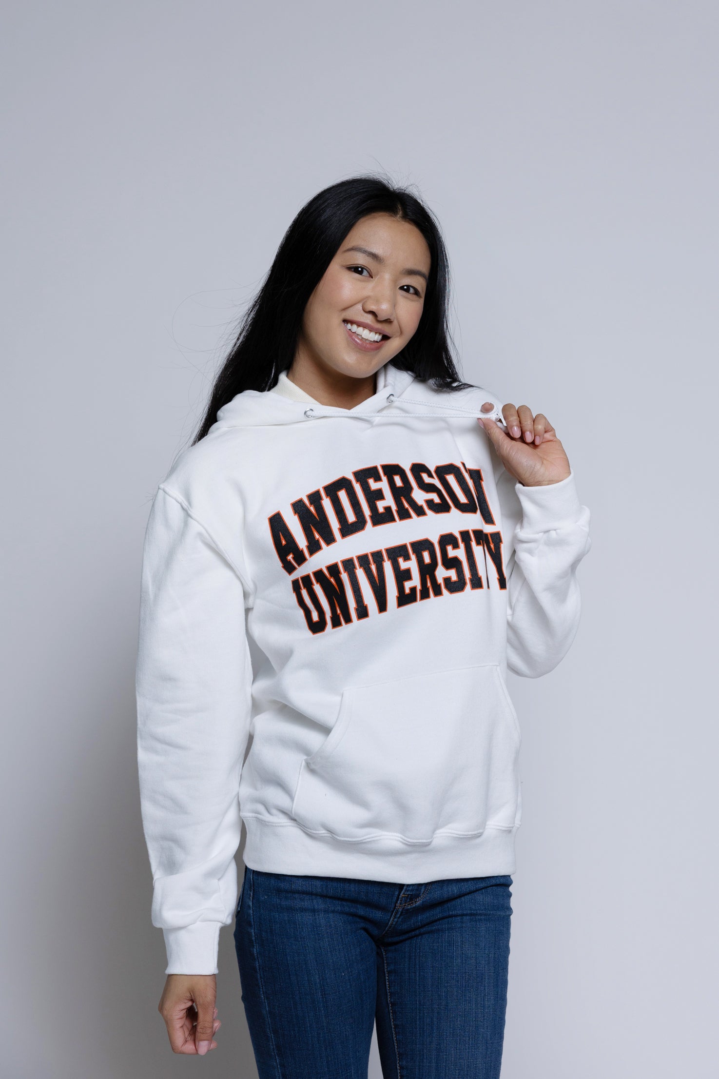 Person wearing a white hoodie with 'Anderson University' printed on it against a plain background