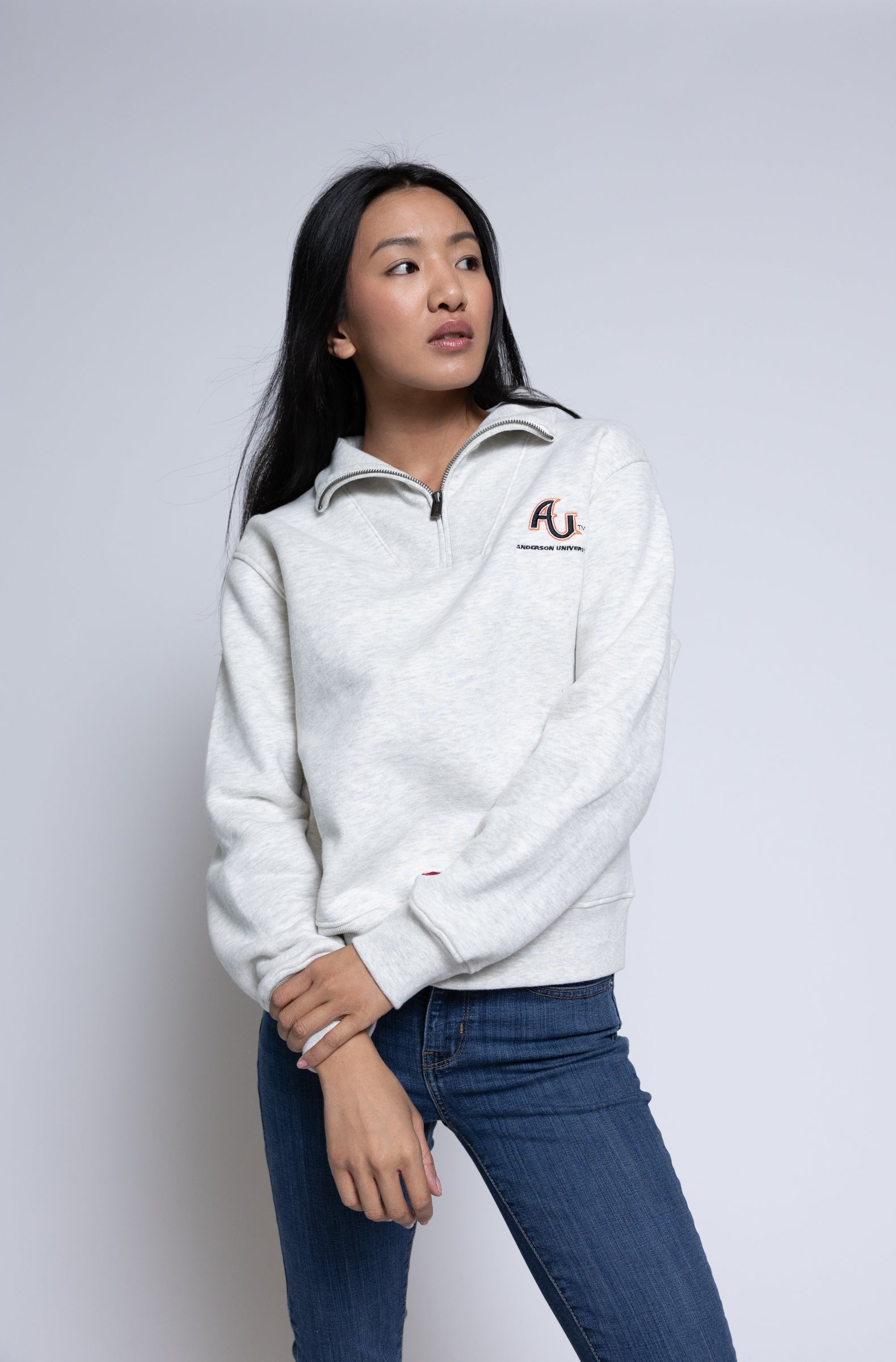 Person wearing a pullover with an AU logo standing in front of a plain background