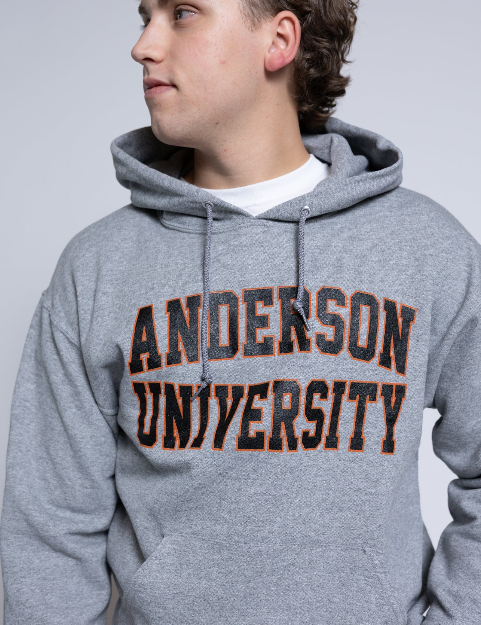 Person wearing a gray hoodie with 'Anderson University' printed on it against a plain background