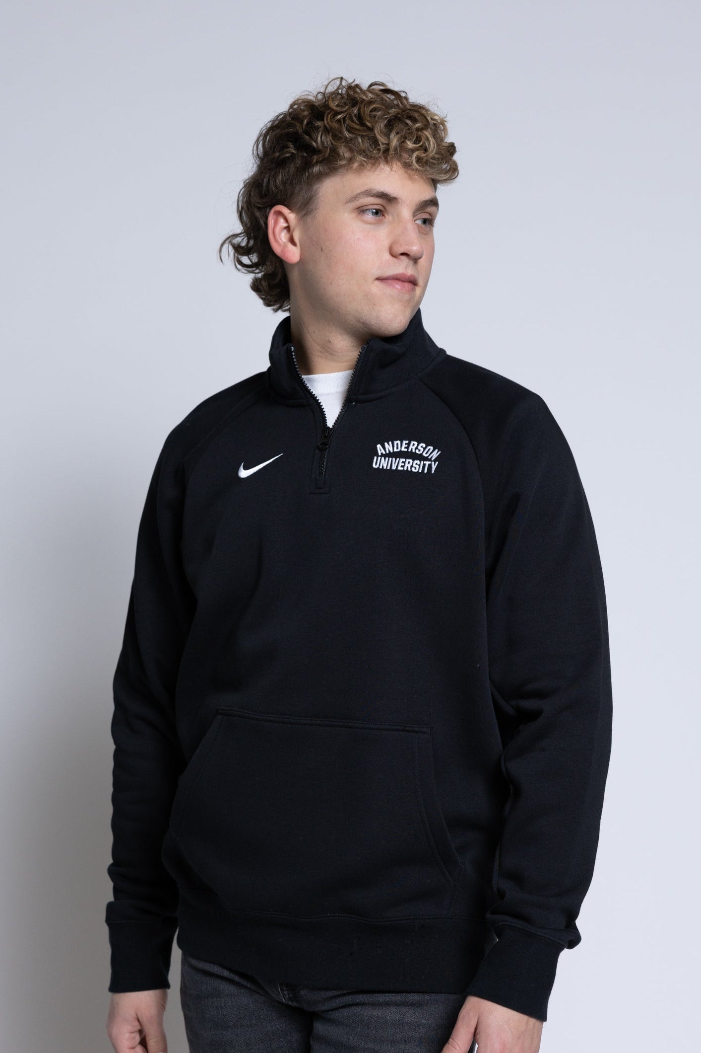 Person wearing a black quarter-zip sweatshirt with 'Anderson University' text on a plain background