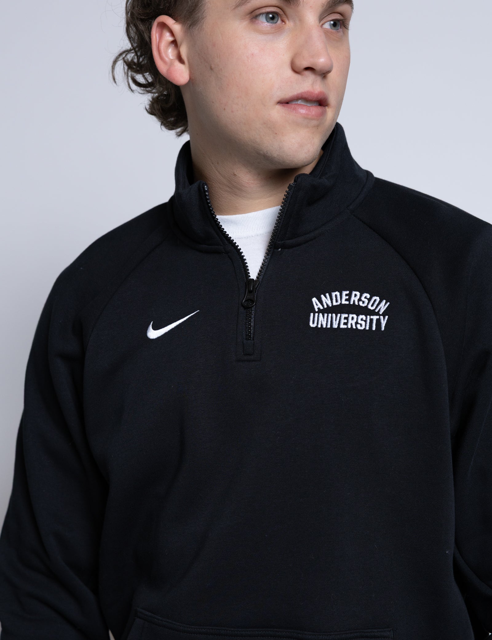 Person wearing a black quarter-zip sweatshirt with 'Anderson University' text on a plain background