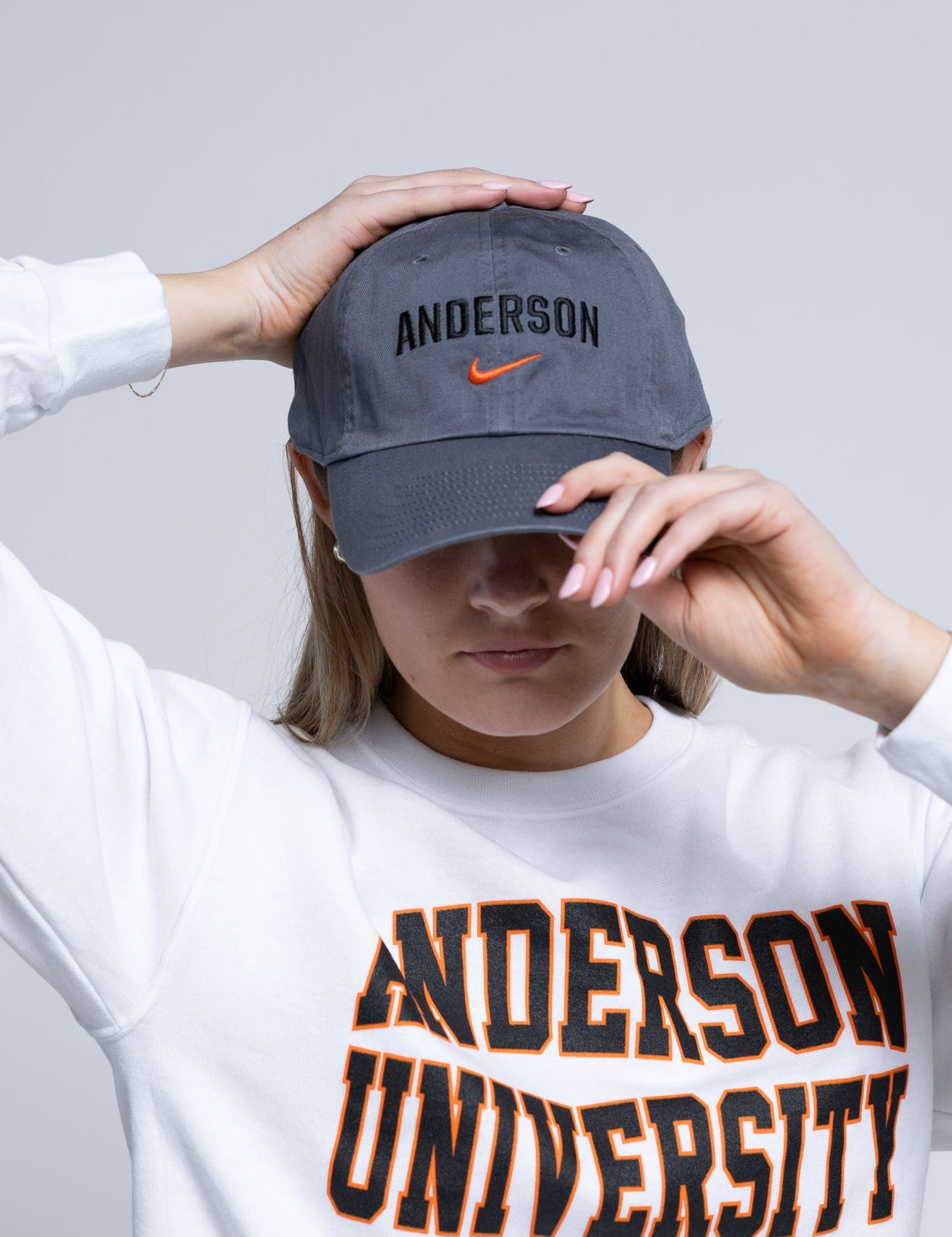 Person wearing a gray cap with 'Anderson' and a white sweatshirt with 'Anderson University' text.