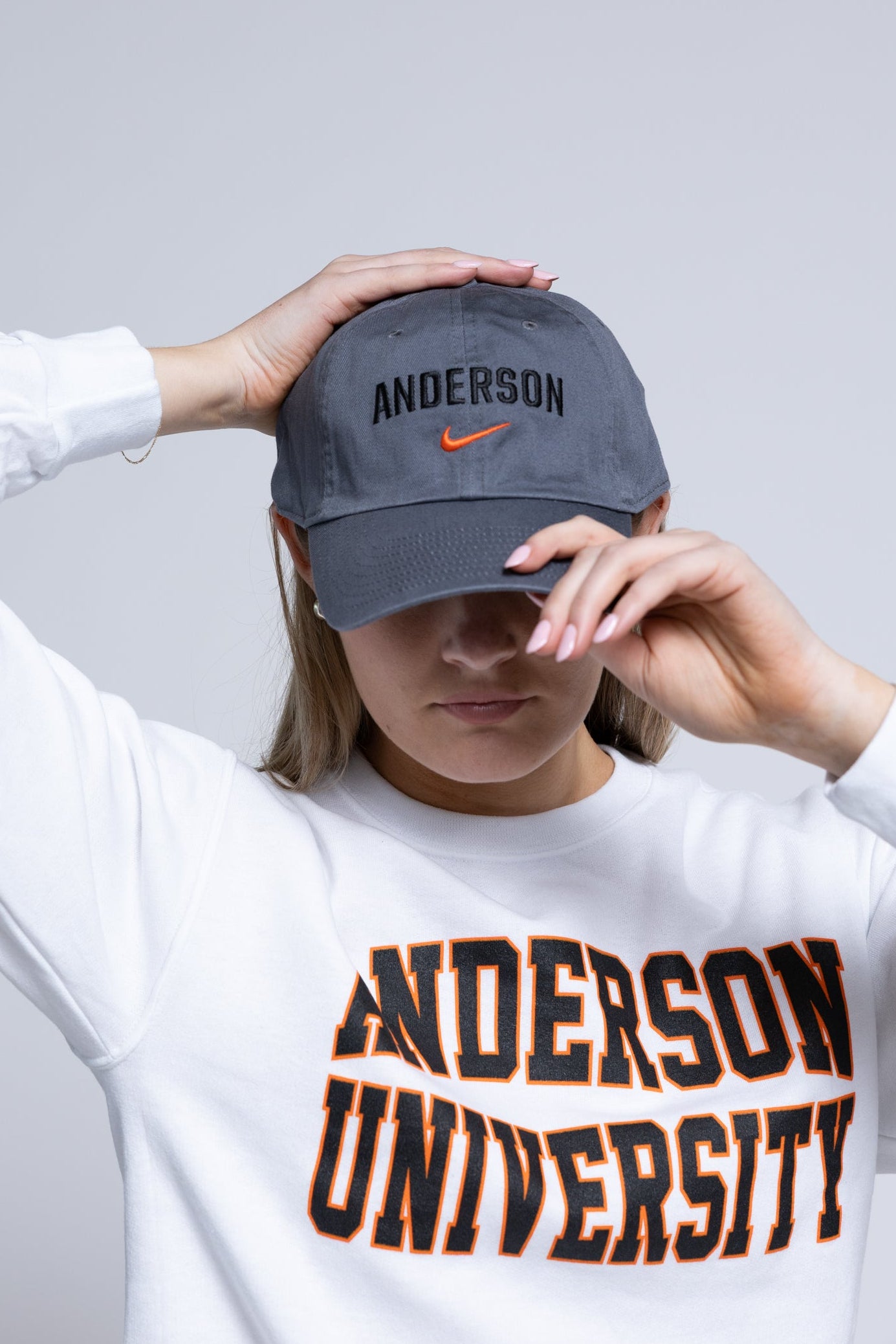 Person wearing a gray cap with 'Anderson' and a white sweatshirt with 'Anderson University' text.